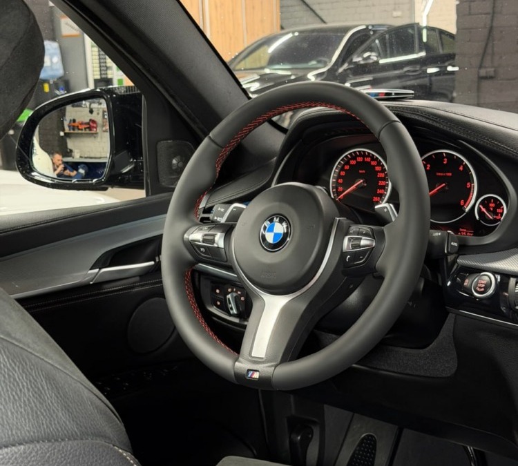 Перетяжка руля BMW X6 натуральной кожей с красной строчкой